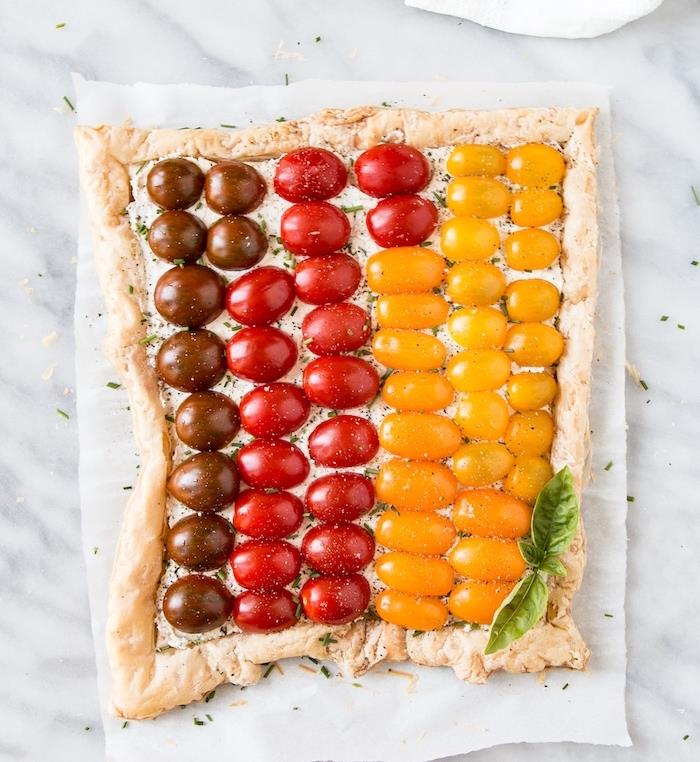 Originálny nápad na aperitív večere s čerešňovým paradajkovým koláčom rôznych farieb so smotanovým syrom a čerstvými bylinkami
