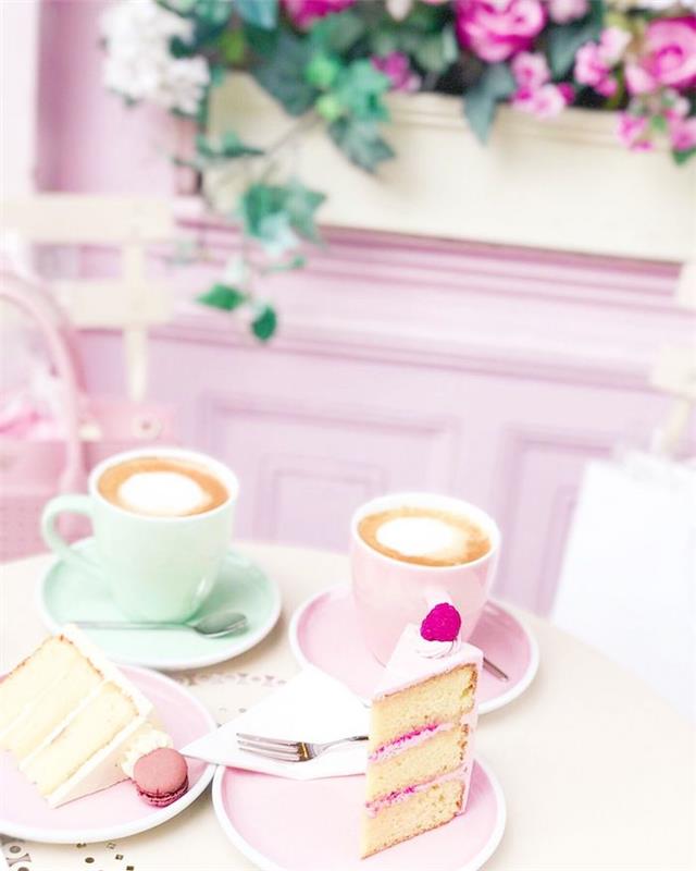 šálky cappuccina a plátok koláča v tanieroch ružové kvety na pastelovom farebnom pozadí