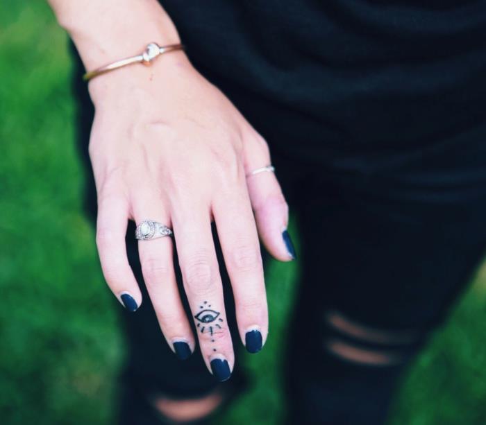 mystický a široko využívaný symbol, minimalistické a jemné tetovanie na prste