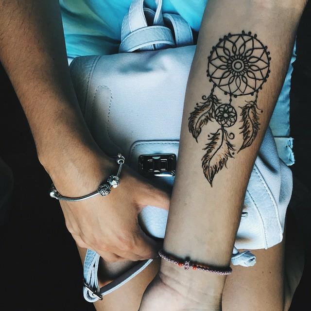 dreamcatcher grafisk underarmstatuering, ring, svart nät och fjädrar, blått armband, handväska och outfit