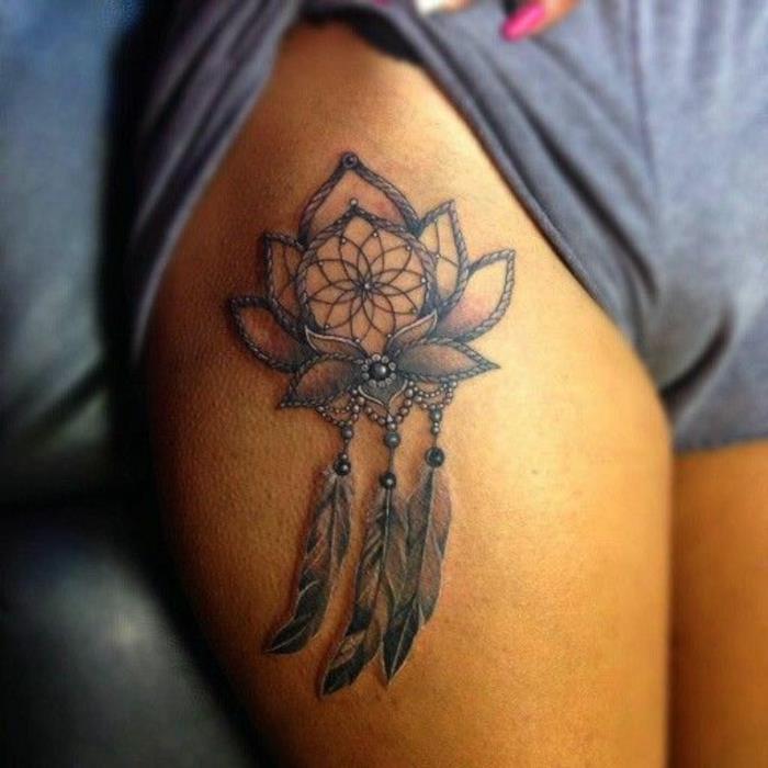 dreamcatcher lår grafisk tatuering med röd och brun skugga, pärlor, lotusblommor, svart bläcknät och fjädrar
