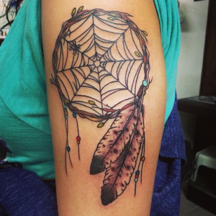drömfångare arm tatuering, spindelnät och trädgrenring, svarta och bruna fjädrar, små dekorativa pärlor