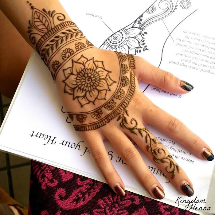 تصميم زهرة اللوتس على اليد وسوار الحناء على المعصم والأصابع