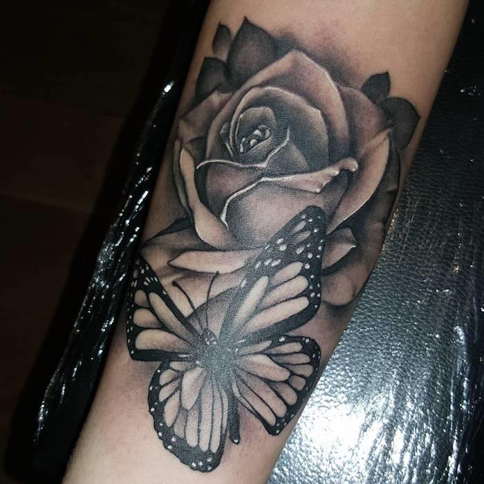 mužské tetovanie kresbou na koži čiernym motýľom a veľkou ružou