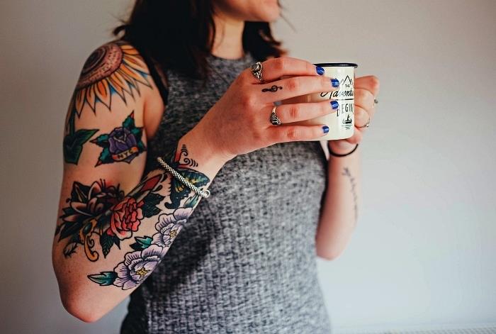 nápad na tetovanie na celú pažu s farebnými kvetinovými vzormi v kombinácii s malým tetovaním na husľové kľúče, slnečnicovým tetovaním na ramene