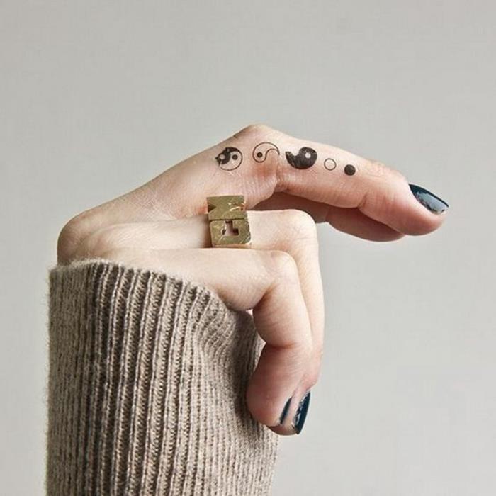en traditionell handtatuering som föreställer yin och yang