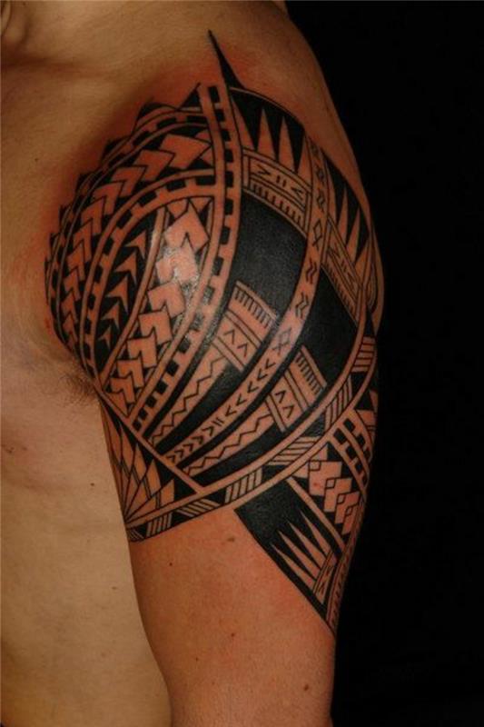 čierne tetovanie, maorské symboly vytetované na ruke, vytetované svalnaté rameno s etnickým imidžom