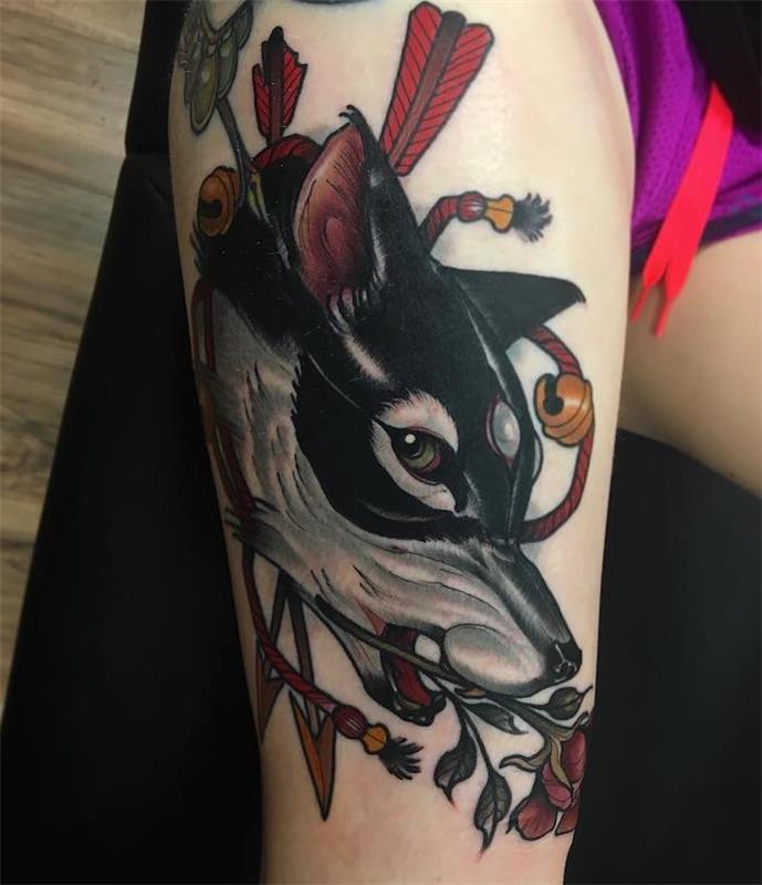 význam tetovania, farebná kresba na ženskej nohe, tvár zlého vlka s červenou ružou