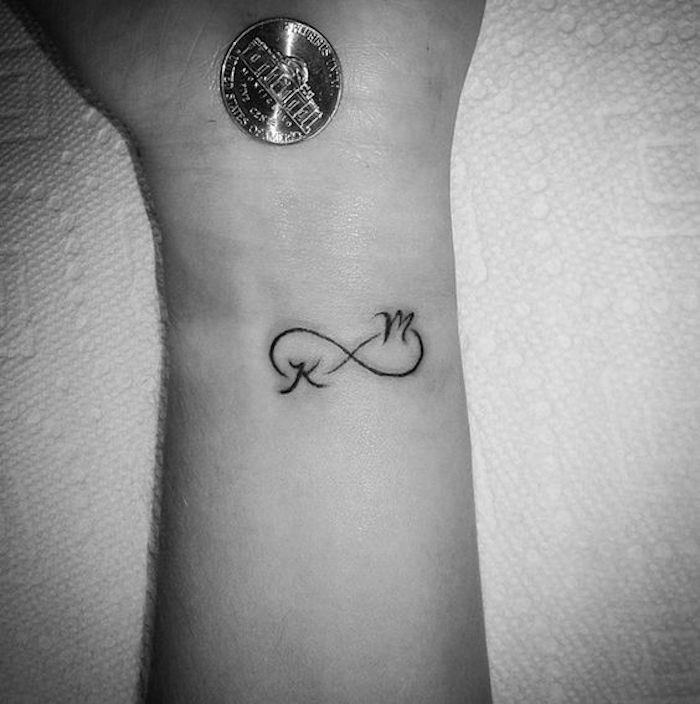 malé tetovanie na zápästí so symbolom nekonečnej večnej lásky a iniciálami