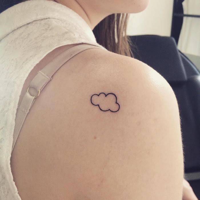 malé diskrétne tetovanie na ramene ženy alebo jednoduché diskrétne cloudové tetovanie