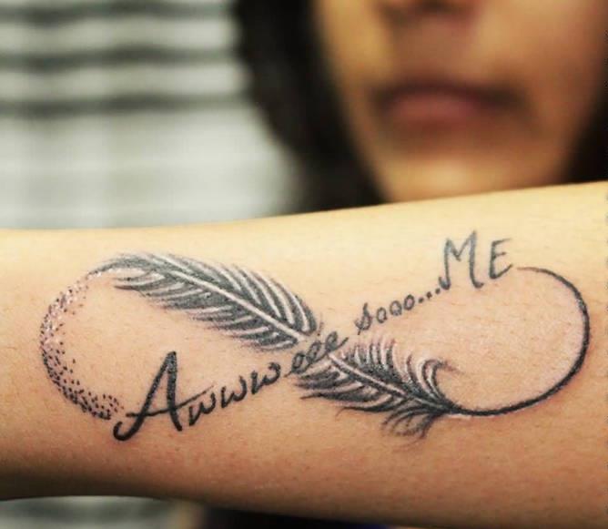 Nekonečné tetovanie s perím na symbole večnosti ženy na predlaktí