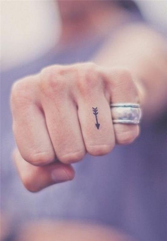 roztomilá malá šípka vytetovaná na prst, diskrétne a jemné tetovanie na prst