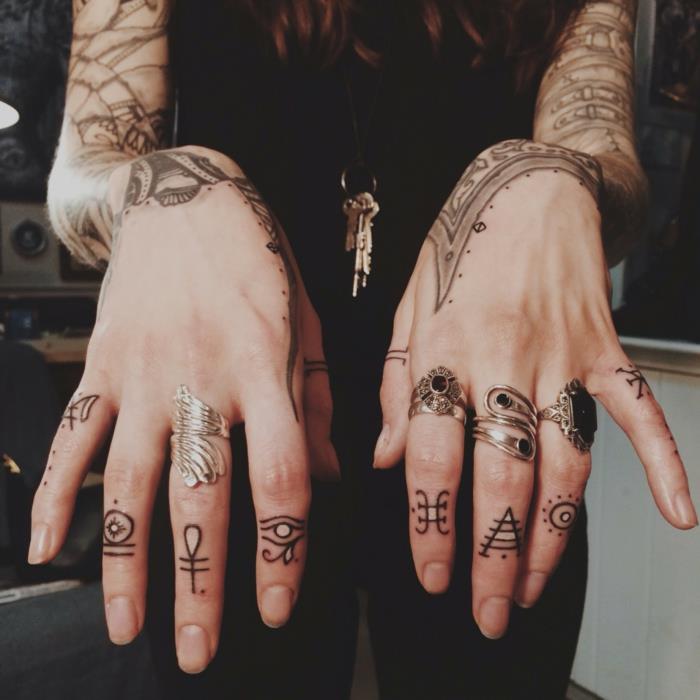 en handtatuering med egyptiska symboler, geometriska tatueringar på varje finger