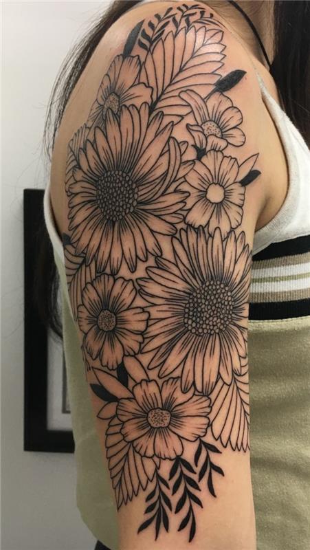 žena s polovičným tetovaním, tetované sedmokrásky, kytica vytetovaná na ruke