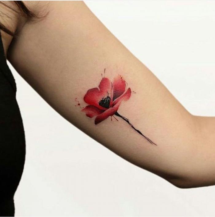 röd akvarell röd akvarell vallmo tatuering på kvinnans arm