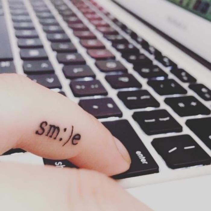 Tatuaggio sul dito, tattoo scritta smile, tastiera del computer