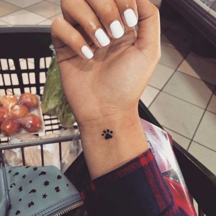 Tatuaggio impronta animal, tattoo sul polso, donna smalt bianco
