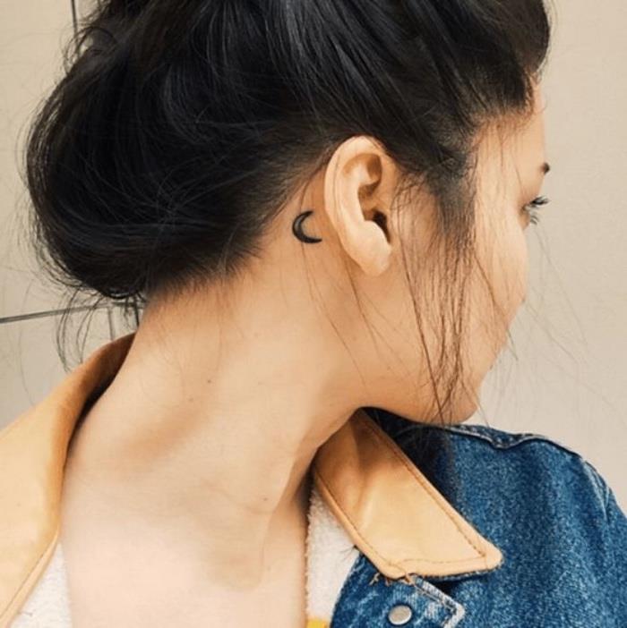 Tatuaggio dietro orecchio, disegno mezza luna, donna con capelli legati