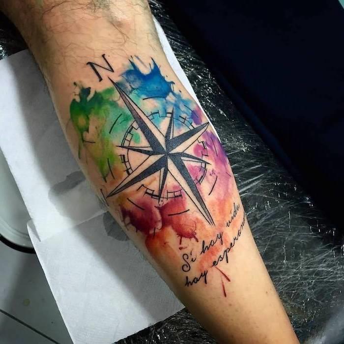 Idé per un tatuaggio braccio uomo con disegno colorato di una bussola con scritta