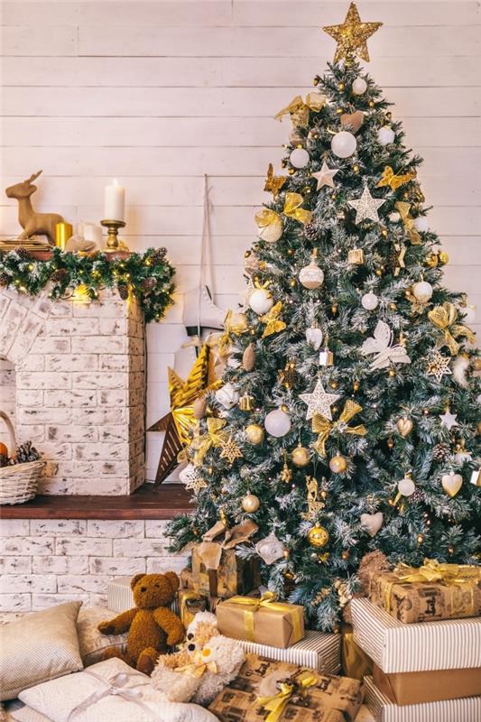 Juldekoration snygg inredning, stort konstgjort träd med snöiga grenar dekorerade med stjärnor och guldband
