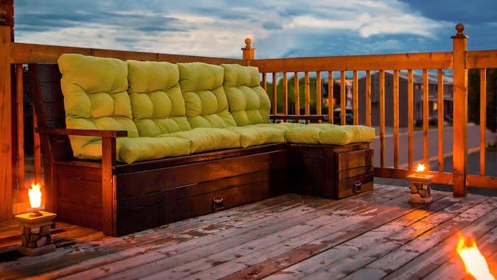 originálna ozdoba terasy s paletovou lavicou s pistáciovým zeleným vankúšom, originálne osvetlenie plameňom