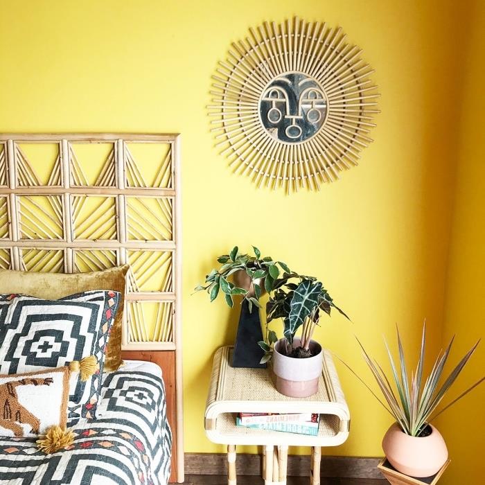 فكرة دهان الحائط لغرفة نوم على طراز الغابة مع جدران صفراء ، نموذج لمرآة من الخيزران على شكل الشمس