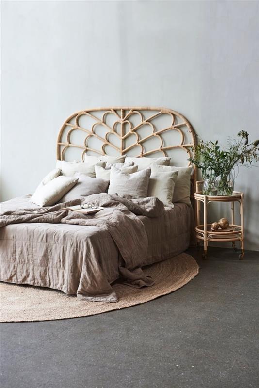 Svetlohnedá spálňa v minimalistickom štýle s manželskou posteľou, nápadom na čelo postele z exotického bambusu a jutovým kobercom