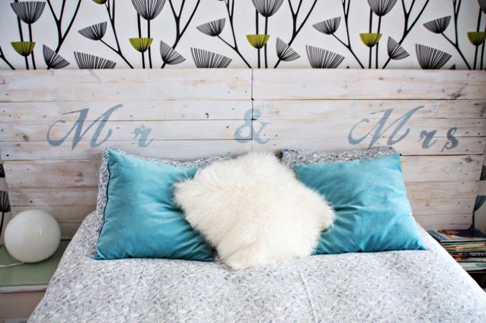 اصنع لوحًا رأسيًا وسريرًا خشبيًا مع بطانية باللونين الأبيض والأزرق الداكن مزينة بوسائد باللون الفيروزي والأبيض