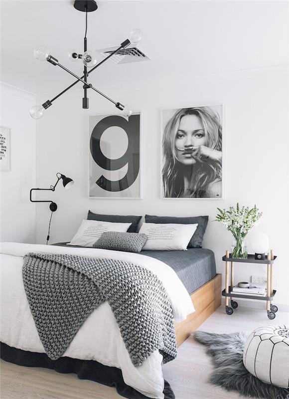 gör skandinavisk sänggavel med grafiska svartvita foton, gråvita sängkläder, sängbord med hjul, vit ottoman