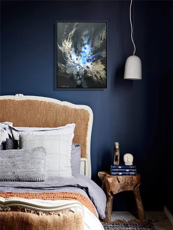 polnočná modrá výzdoba spálne s nábytkom zo surového dreva, príklad kokonovej postele s rustikálnym čelom a ozdobnými vankúšmi
