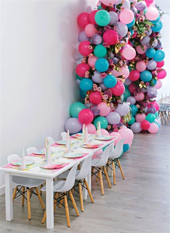födelsedagsborddekorationer på enhörningstemat med en iriserande bordsmatta, båge av rosa, blå och lila ballonger