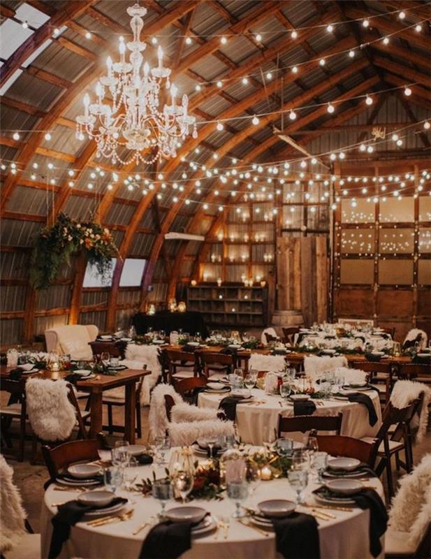 elegantný luster a svetelný veniec na ozdobenie klenutého stropu, okrúhle stoly zdobené čiernobielo, vegetačné centrum a sviečky