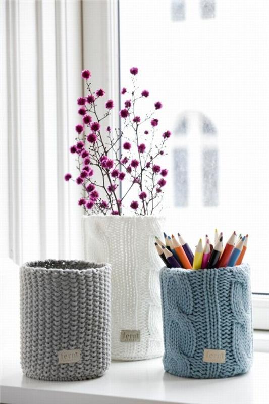 plåtburkar för hantverk, tre burkstickade pennhållare i grått, vitt och ljusblått, innehållande färgpennor och en torkad lila växt