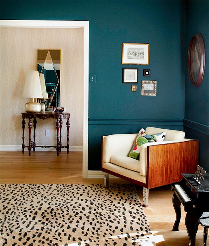 modern inredning, mörkblå målad vägg, sänglampa beige och koppar, rektangulär spegel med geometriska mönster