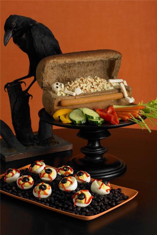 halloweensky prípitok na chlebovej truhle s kostrou čertovských krvavých vajíčok a ozdobným havranom