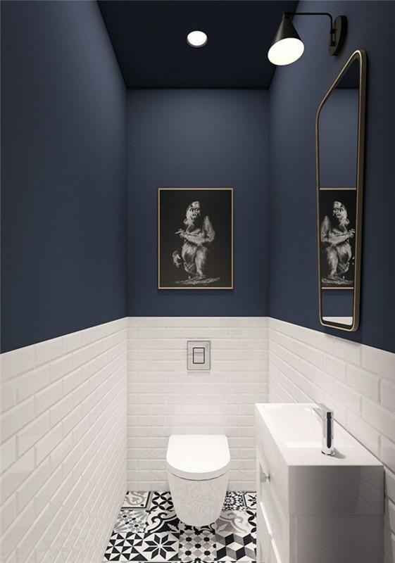 Kúpeľňové armatúry v modrej a bielej farbe, biela dlažba metra, zrkadlo s rámom, podlaha z cementovej dlažby