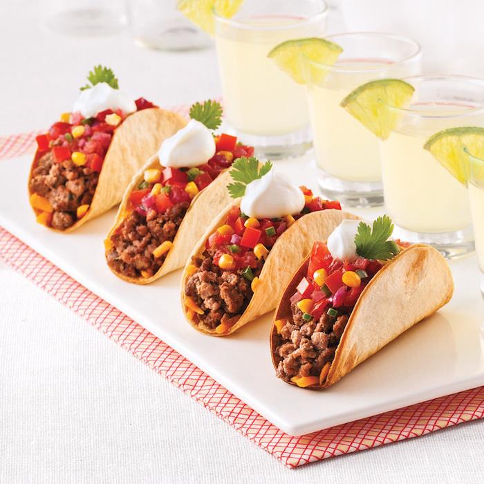 Tacos con carne, tortillas con salsa bianca, bevande con fettine di lime