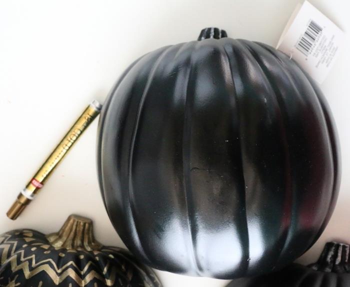 halloween pumpamodell, gyllene nyanspenna att rita på den svarta pumpan, polystyrenpumpa för halloween