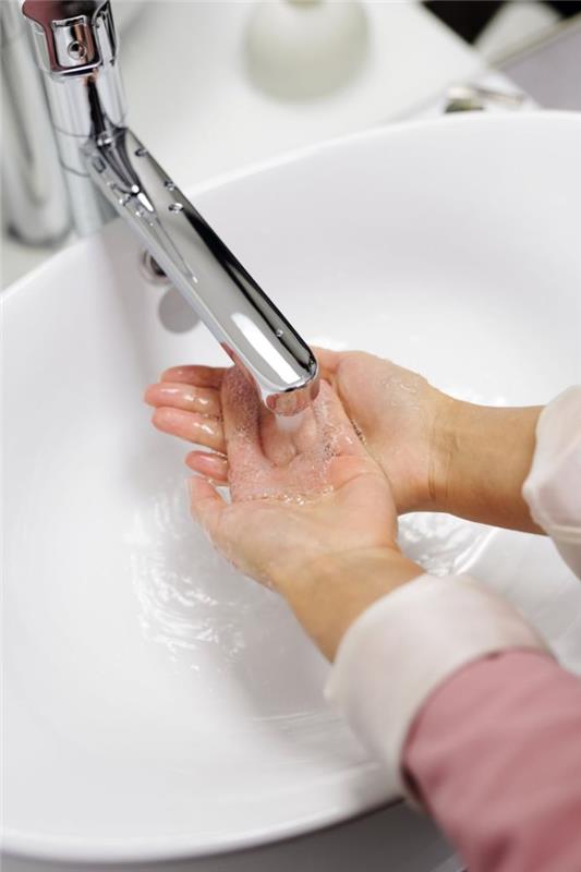 Disinfettante per le mani fatto in casa، donna che si lava le mani sotto l'acqua con sapone