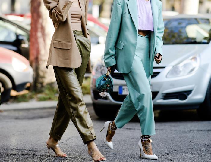 اتجاهات الملابس لعام 2019 ، امرأتان تمشيان في الشارع ، إحداهما ترتدي سروالاً جلدياً أخضر اللون ، بدلة فيروزية بكعب أبيض