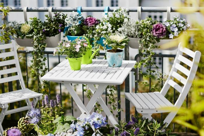 balkong, ordna sin terrass, fällbord och vita stolar, dekoration av blomkrukor med färgglada blommor