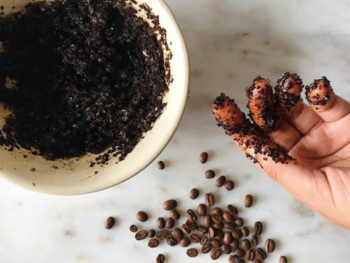 en hand med kaffesumpfläckar från kaffebönorna på en marmoryta