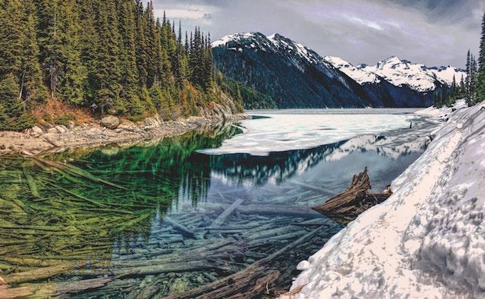 vinterlandskap visslaren i snö, en flod med kristallklart vatten, skogar och berg runt, spektakulär utsikt, vad du ska besöka i Kanada