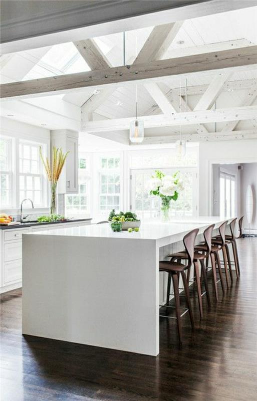 stort-kök-med-trä-bar-stol-hög-bar-vita-blommor-ljuskrona-stort-fönster