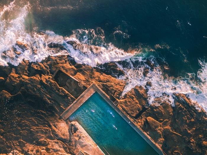 fotka pre bezplatnú tapetu s prímorskou krajinou, obraz vĺn lámajúcich sa o skalu a veľký otvorený bazén