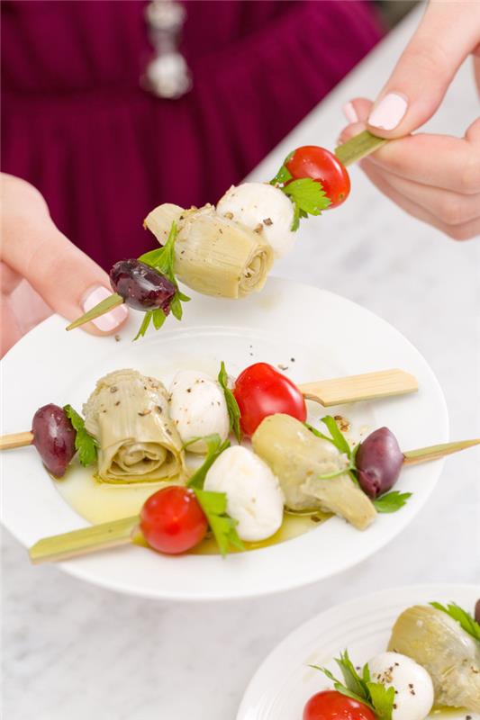 veggie pinwheels, oliver och lök, mozzarella och körsbärstomater, på ett träspett