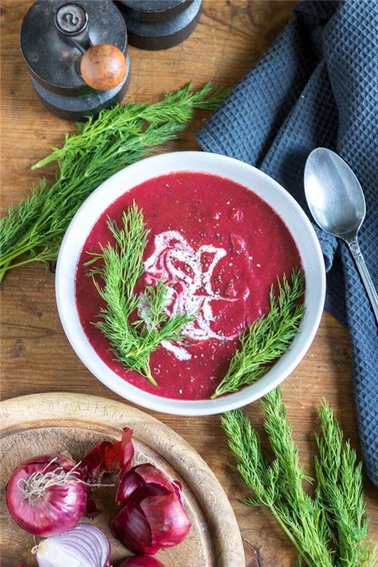 Vellutate Invernali ، Minestra Frullata di pomodoro e cipolla ، piatto guarnito con erbette fresche