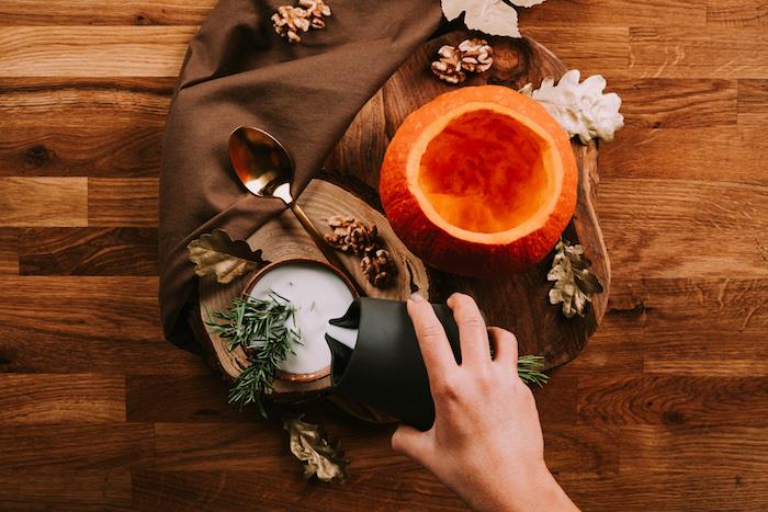 Ricette Vellutate ، zucca intagliata dal ripieno ، ciotola con latte di cocco ، decorazioni autunnali
