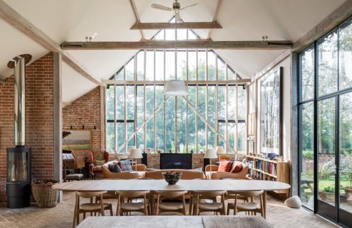 projekt obnovy stodoly, dispozícia obývačky v podkroví s bielym a dreveným stropom s hnedým koženým nábytkom a drevenými akcentmi