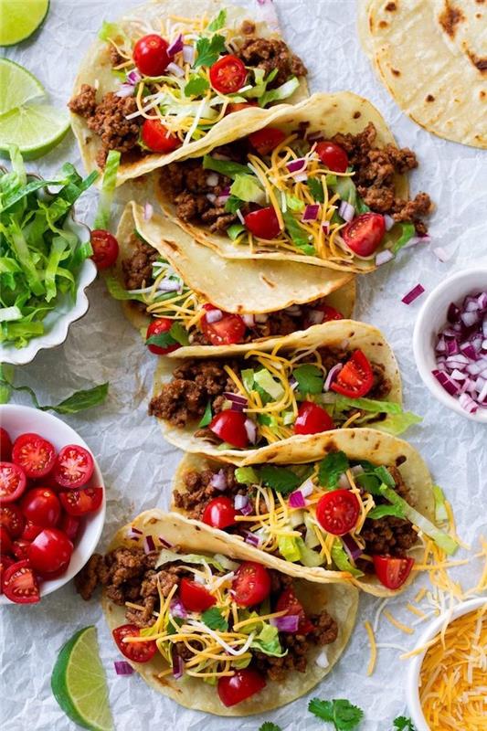 Piatti messicani, tacos con carne, ciotola con pomodorini, insalata romana tagliata